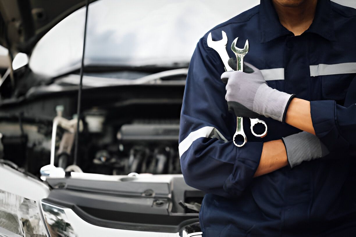 mechanic works on the engine of the car in the garage