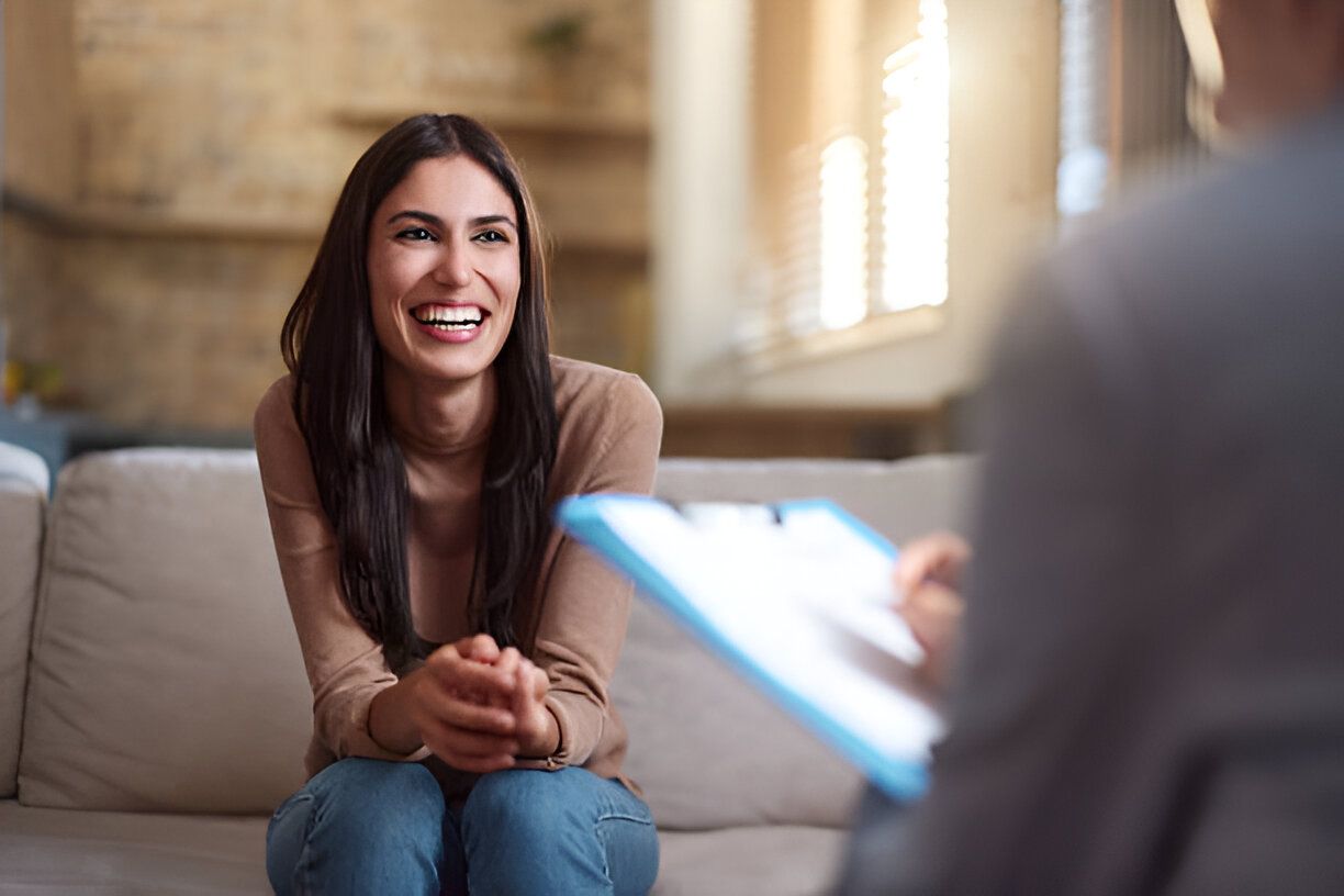 Young happy woman communicating with a therapist during a home visit.